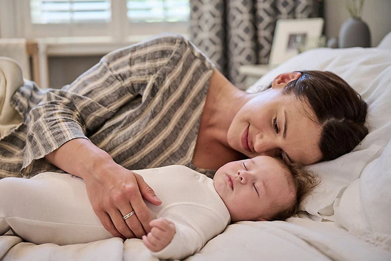 Em bé đang ngủ yên trong cũi, minh họa giấc ngủ ngon và sâu của trẻ sơ sinh