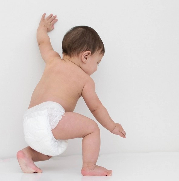 Em bé đang tập đi với chiếc tã bị xệ, minh họa tã xệ ảnh hưởng dáng đi