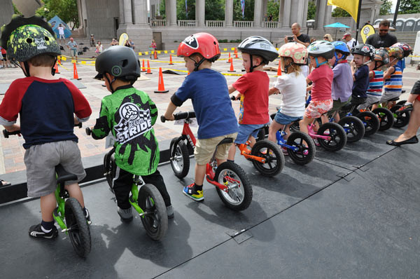 Bé gái ngồi thử xe đạp màu hồng trên đường