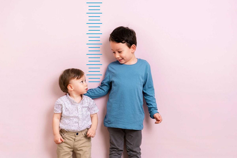 Bé trai được đo chiều cao định kỳ để theo dõi sự phát triển