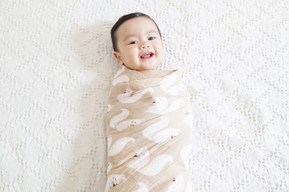 Hình ảnh một em bé sơ sinh được quấn chăn đúng cách, an toàn khi ngủ, minh họa lợi ích và kỹ thuật quấn chặt trẻ sơ sinh khi ngủ