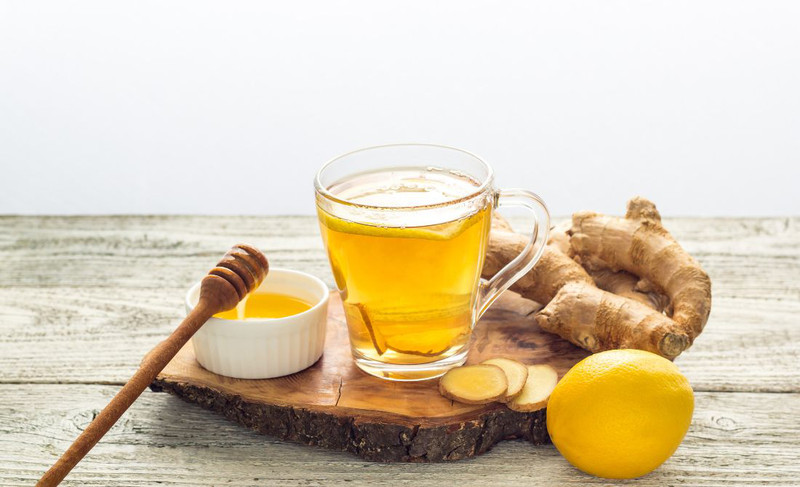 Hình ảnh một phụ nữ đang uống trà chanh mật ong ấm, thể hiện cách trị ho bằng mật ong hiệu quả.