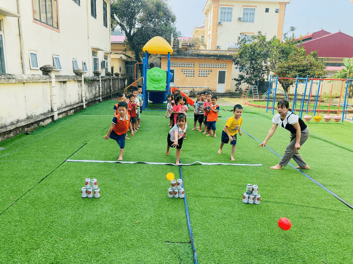 Một nhóm trẻ mầm non vui đùa với các trò chơi hoạt động ngoài trời