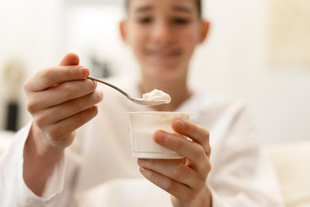 Hũ sữa chua bị tách nước với lớp whey vàng nhạt, minh họa tình trạng sữa chua bị tách nước có ăn được không