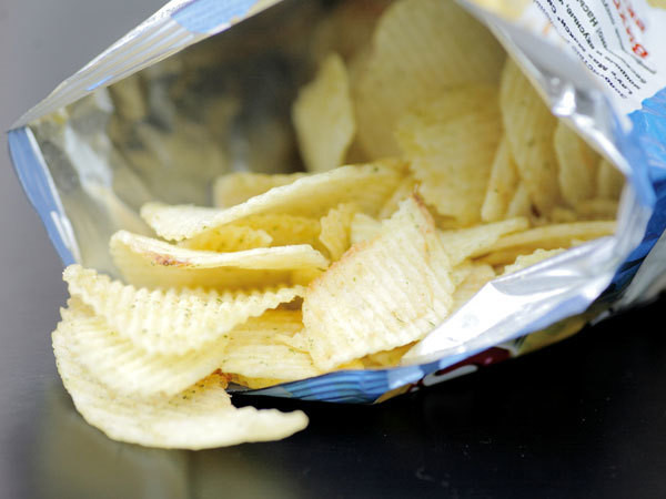 Một loạt các gói snack khác nhau với kích thước và nguyên liệu đa dạng, minh họa cho sự khác biệt về lượng calo trong 1 gói snack