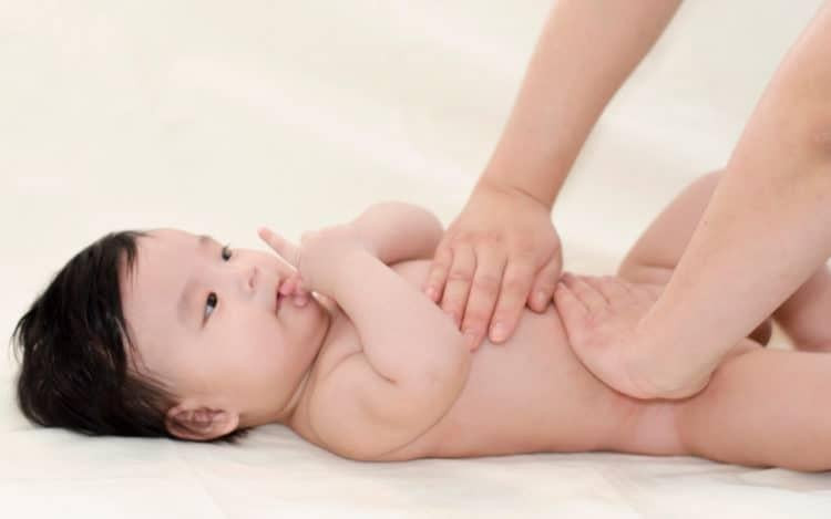 Người lớn nhẹ nhàng massage chân cho bé, tạo sự kết nối và thư giãn cho trẻ.