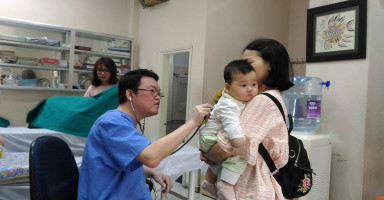 TS.BS Đào Đình Thi đang khám tai mũi họng cho trẻ tại phòng khám chuyên khoa.