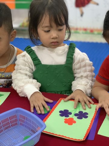 Bé gái đang cắt giấy làm thiệp chúc mừng 20 10