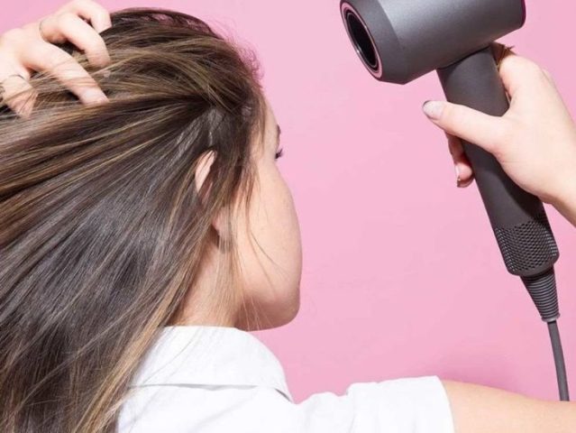 Sấy tóc tương đối khô theo chiều từ trên xuống dưới để làm thẳng tóc bằng máy sấy