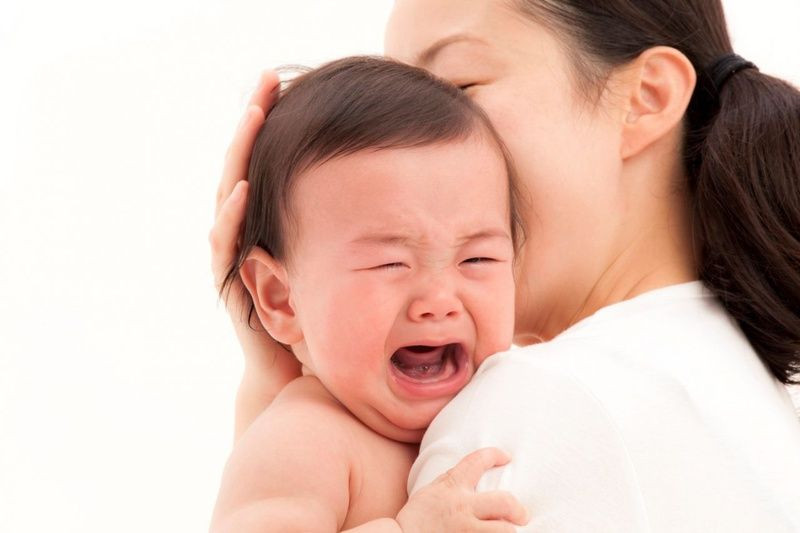 Bé bị tiêu chảy và sốt đang được cha mẹ vỗ về, tìm cách hạ sốt