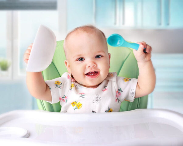 Bé đang tập trung tự xúc ăn một cách độc lập với sự hướng dẫn của cha mẹ