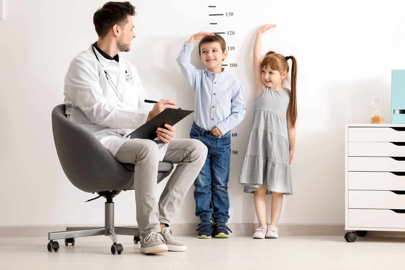 Bé gái 5 tuổi đang tự đo chiều cao tại nhà, biểu thị sự quan tâm đến cân nặng và sự phát triển.