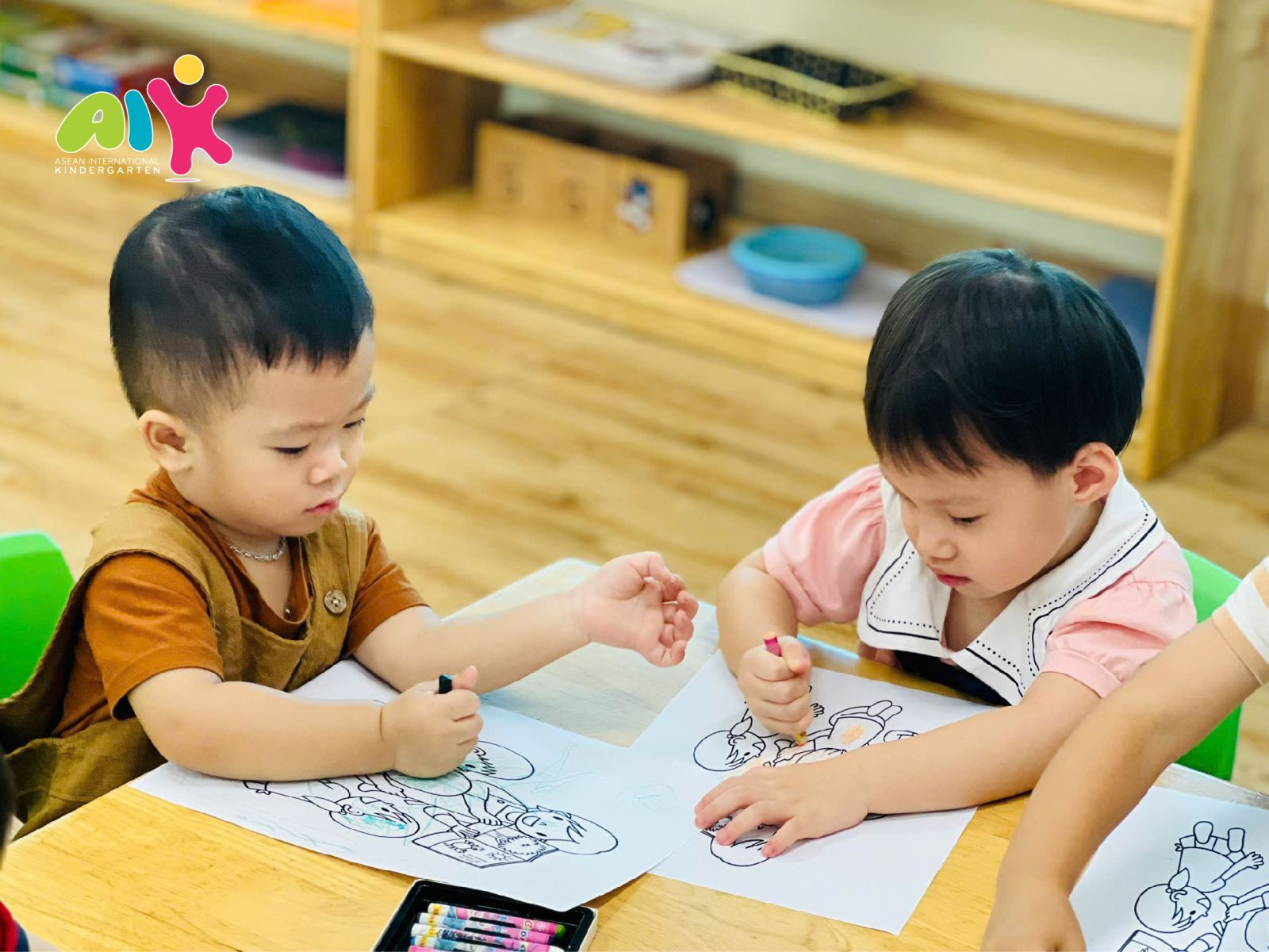 Bé gái đang tô màu tranh cô giáo và các bạn