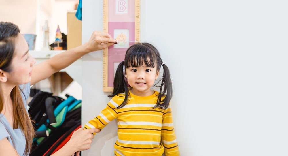 Bé gái được đo chỉ số cân nặng chiều cao của trẻ tại nhà