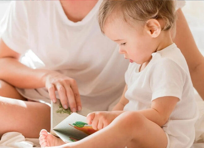 Bé gái khám phá sách ảnh đầy màu sắc, một lựa chọn quà tặng sinh nhật cho bé gái 1 tuổi để phát triển nhận thức