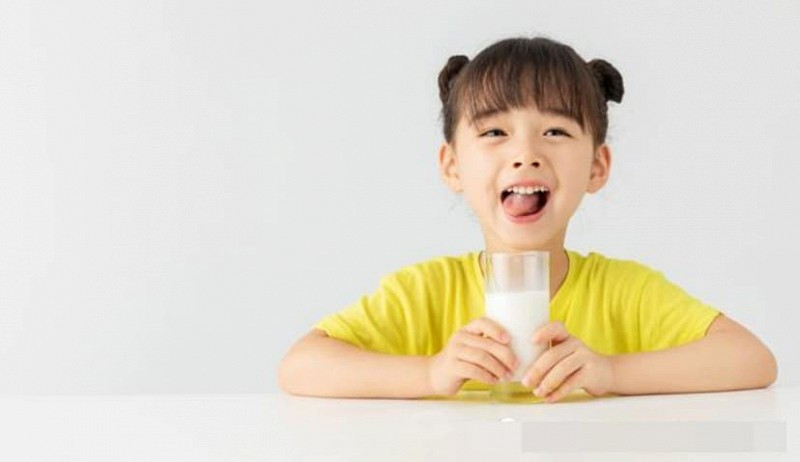 Bé gái uống sữa trong hộp giấy tiện lợi