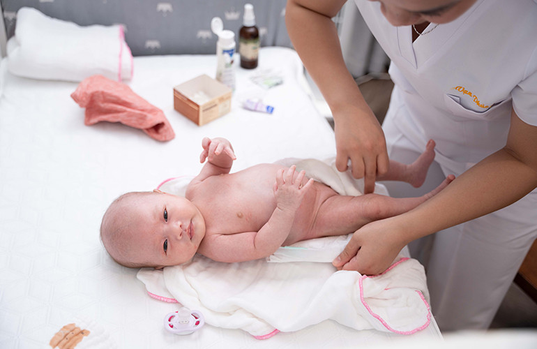 Bé sơ sinh nằm trên khăn mềm mại, sẵn sàng cho bước đầu tiên trong cách tắm cho bé sơ sinh tại nhà.