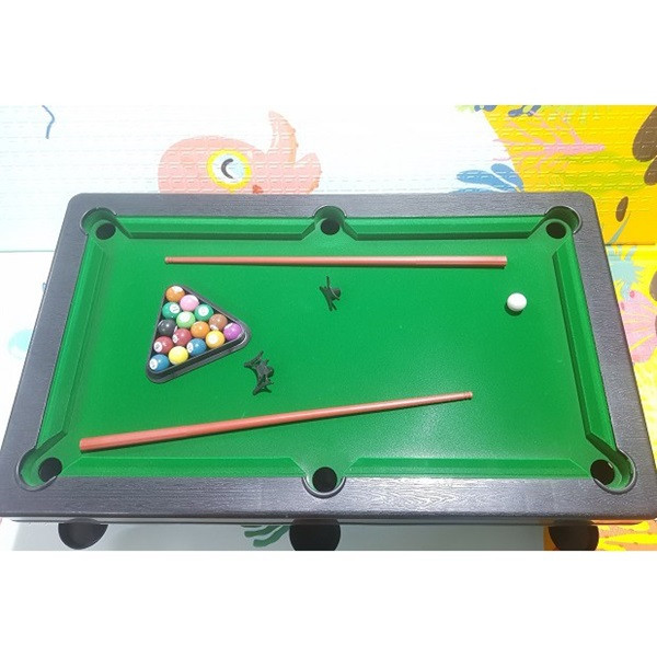 Bé trai 10 tuổi đang chơi bàn bida lỗ thu nhỏ, một món đồ chơi rèn luyện sự khéo léo và tư duy chiến thuật