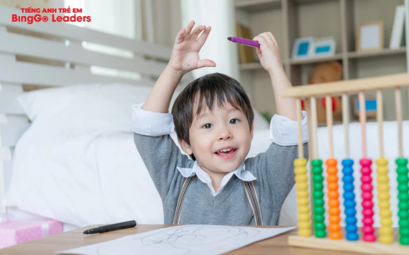 Bé trai 3 tuổi vui vẻ trượt cầu trượt, thể hiện khả năng vận động của trẻ 3 tuổi trong các hoạt động vui chơi.