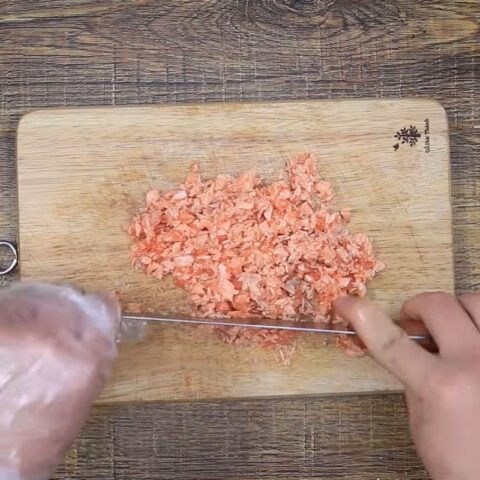 Cá hồi đã luộc chín được vớt ra khỏi nước để chuẩn bị làm cháo cá hồi cà rốt