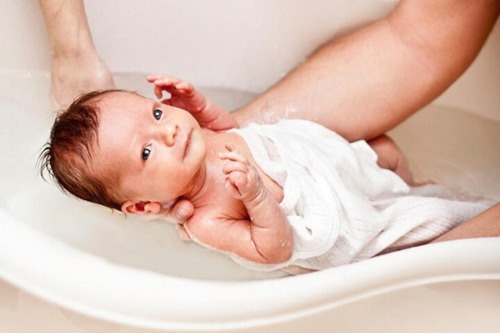Cách chăm sóc trẻ sơ sinh giãn ruột: tắm nước ấm giúp bé thư giãn