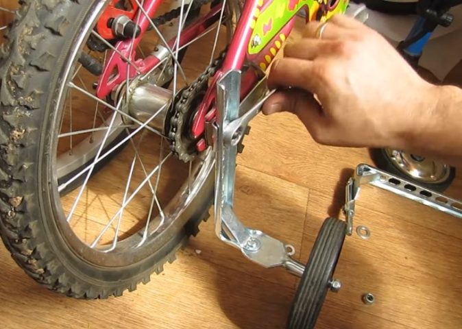 Sử dụng cờ lê siết chặt ốc để lắp bánh phụ xe đạp trẻ em an toàn