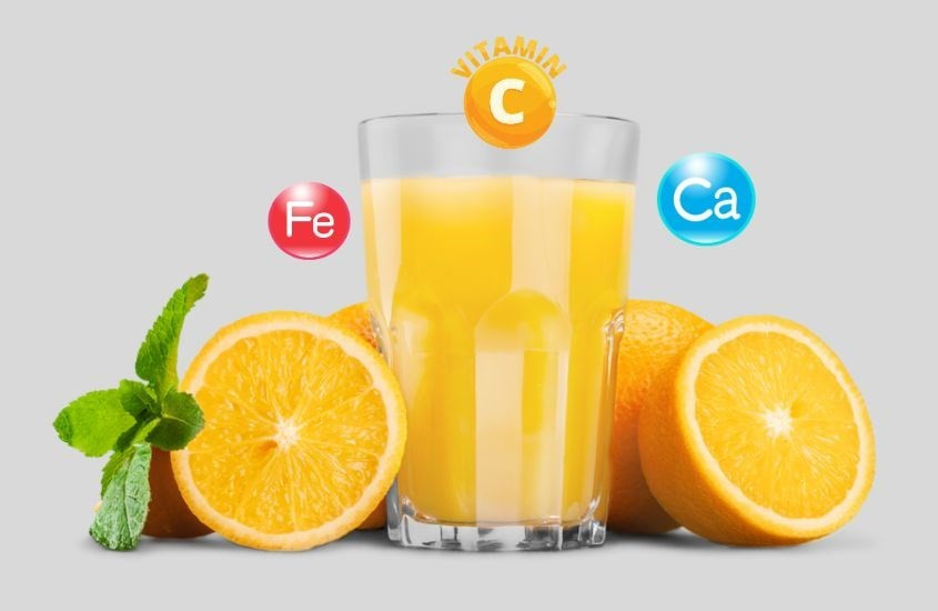 Đĩa cam tươi cắt lát và cốc nước cam ép, thể hiện nguồn dinh dưỡng dồi dào