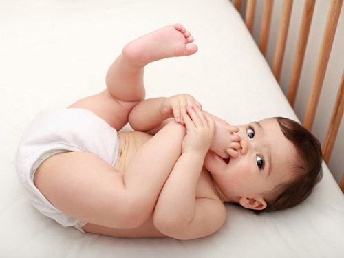 Em bé 8 tháng tuổi vui vẻ ngồi chơi, biểu hiện sự phát triển của trẻ 8 tháng tuổi về khả năng vận động và nhận thức