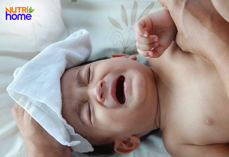Em bé đang được đo nhiệt độ, một trong những lý do khiến bé không chịu uống sữa ngoài khi bị ốm hoặc sốt.