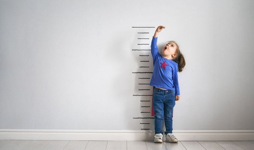 Em bé vui vẻ uống nước cam, liên quan đến sự phát triển chiều cao và trí não