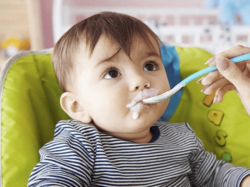 Hình ảnh bé gái đang ăn sữa chua, giúp mẹ tìm hiểu trẻ ăn sữa chua có tốt không và cách dùng hiệu quả