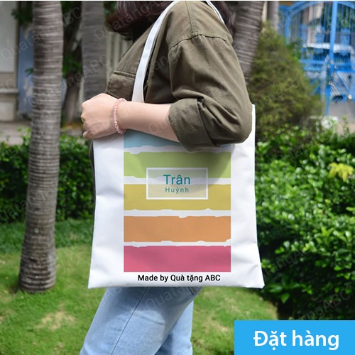 Hình ảnh một chiếc bánh sinh nhật nhỏ màu hồng nhạt, được đặt trên một đĩa nhỏ, với phông nền là những cây nến lung linh và ánh sáng lấp lánh.