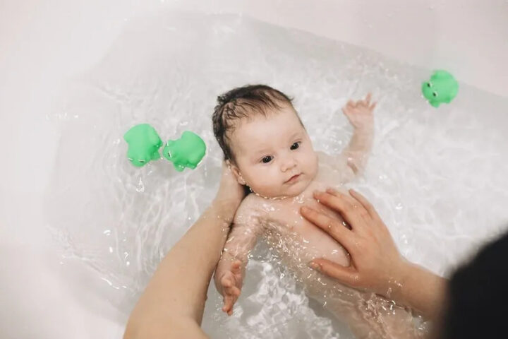 Kiểm tra nhiệt độ nước bằng tay trước khi pha nước tắm cho bé sơ sinh