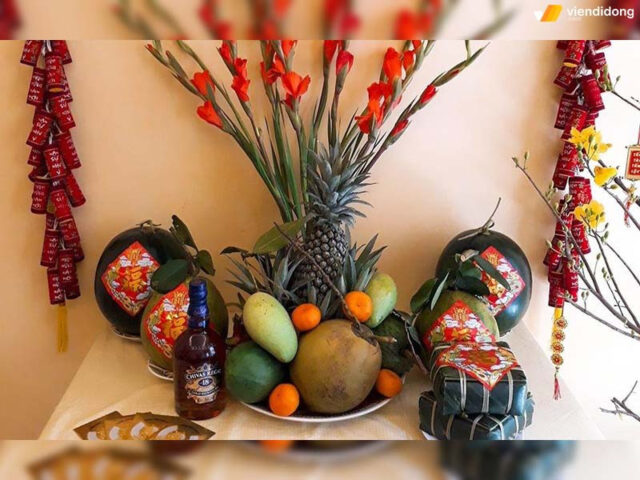 Mâm ngũ quả ngày Tết đẹp đậm chất truyền thống với bánh chưng, rượu, và hoa mai vàng