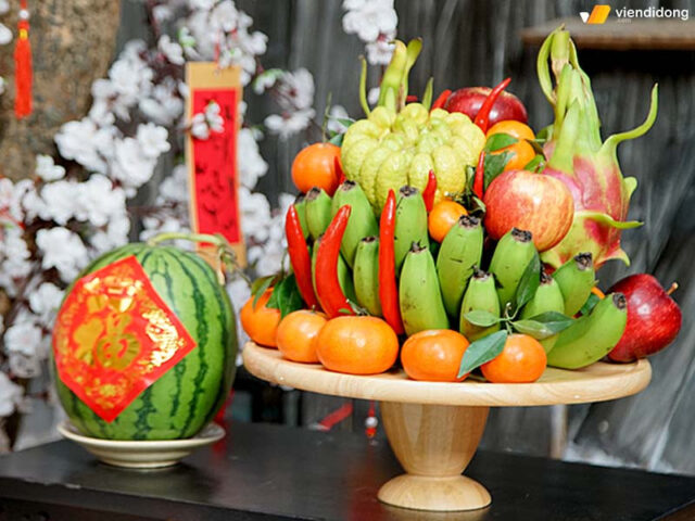 Mâm ngũ quả ngày Tết đẹp và sang trọng, kết hợp hài hòa với những cành hoa tươi tắn, tạo điểm nhấn tinh tế