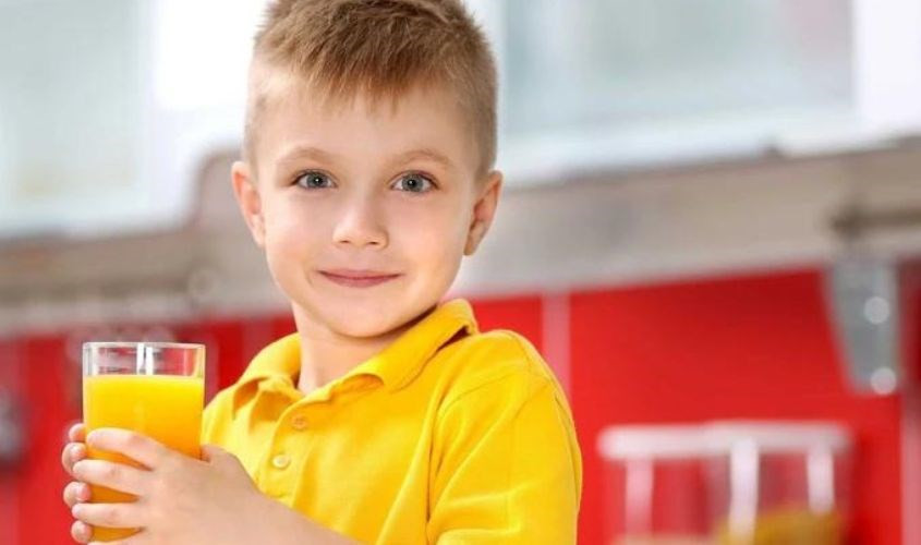 Mô tả hình ảnh em bé vui vẻ uống nước cam sau bữa ăn sáng hoặc trưa