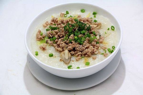 Một bát cháo thịt băm gừng ấm nóng, tượng trưng cho món ăn nhẹ nhàng, bổ dưỡng sau khi xông hơi giúp phục hồi năng lượng và làm ấm cơ thể.