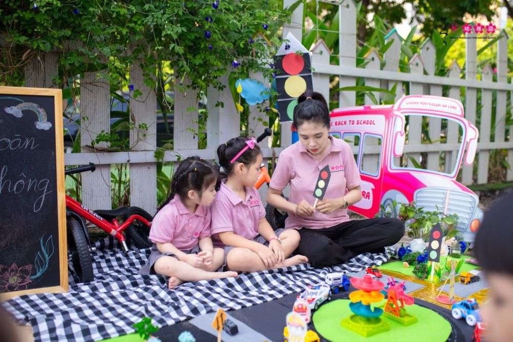 Một cô giáo đang trò chuyện với bé nhỏ tại trường, hình ảnh minh họa cho việc chuẩn bị cho bé đi học mẫu giáo bằng cách làm quen sớm với cô giáo.