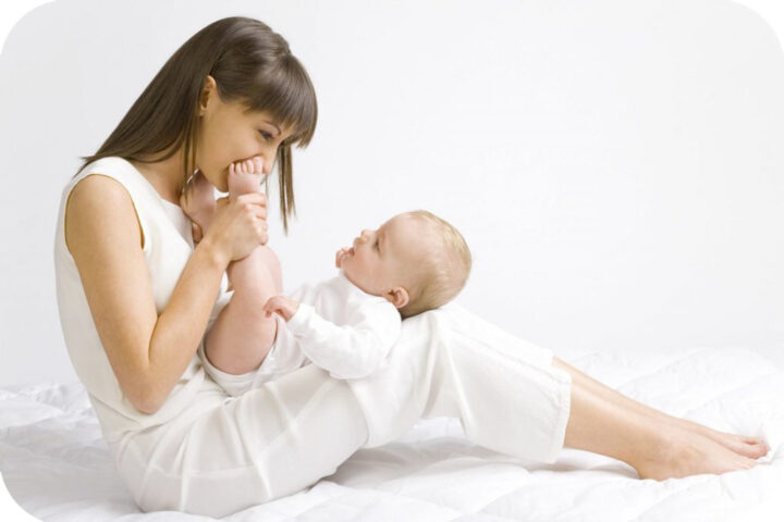 Người mẹ âu yếm chạm vào khuôn mặt bé bỏng của con