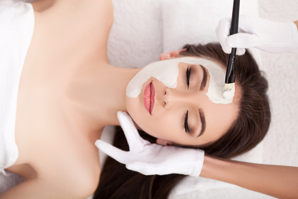 Người phụ nữ chạm vào làn da mịn màng sau khi dùng mặt nạ tốt nhất hiện nay