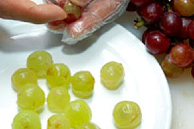 Người phụ nữ đang bóc vỏ nho, minh họa cách ăn nho an toàn cho bà bầu, đặc biệt khi tìm hiểu có bầu ăn nho được không và cách chế biến.
