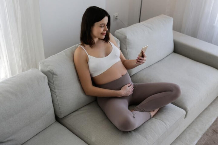 Người phụ nữ đang sử dụng app theo dõi thai kỳ miễn phí trên điện thoại, nhập thông tin sức khỏe