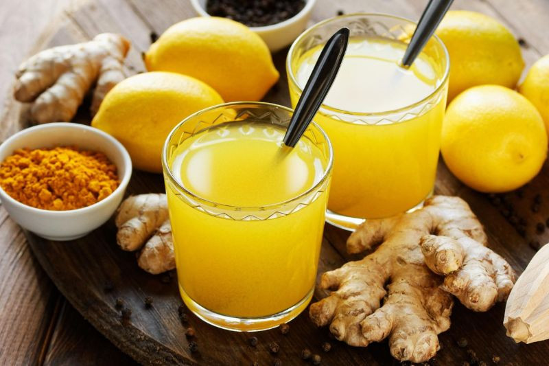 Người phụ nữ đang uống nước chanh với bột nghệ trị nám da, một thức uống thanh lọc cơ thể