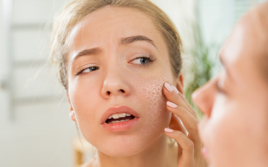 Người phụ nữ dùng bông tẩy trang làm sạch da mặt buổi sáng, cân nhắc có nên tẩy trang buổi sáng để tránh kích ứng