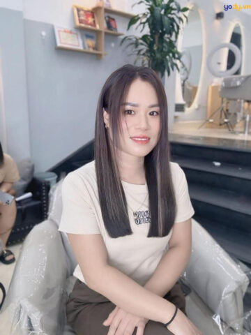 Người phụ nữ sấy tóc bằng máy sấy, hướng tóc thẳng xuống