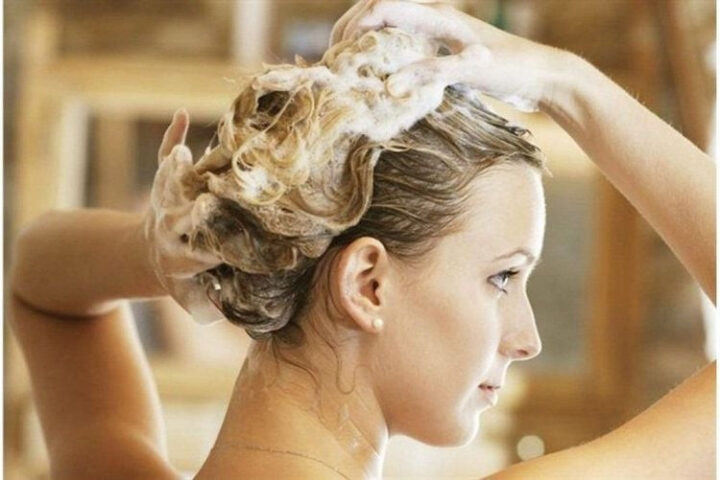 Phụ nữ lo lắng khi tóc rụng nhiều trong lúc gội đầu do các vấn đề sức khỏe
