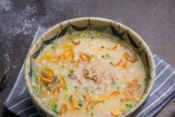 Thêm hành lá, tiêu xay, hành phi và thưởng thức cháo bí đỏ đậu xanh thịt bằm ngay khi còn nóng